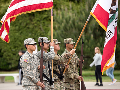 Soldiers holding and raising the U.S. flag, representing military service and veteran recognition